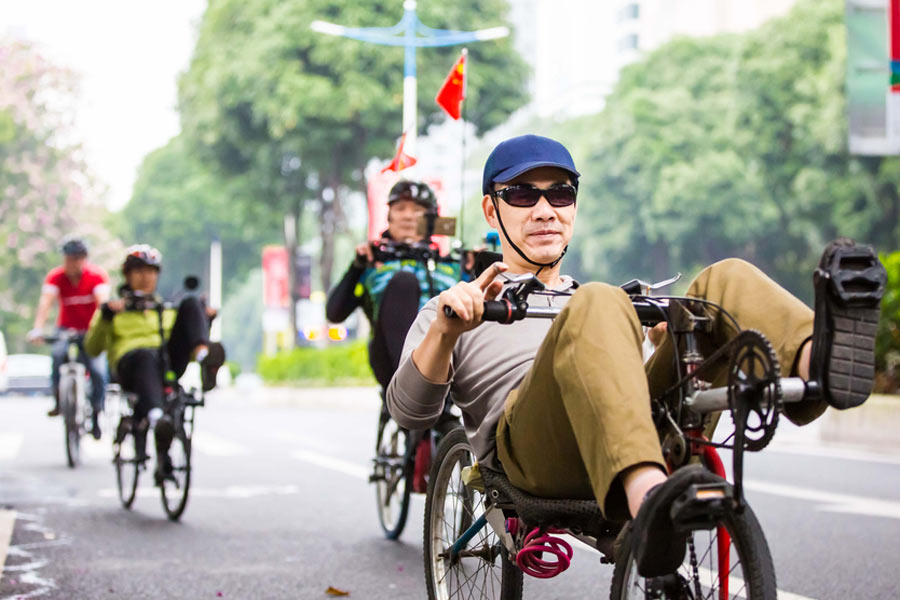 Cyclists sit back as they pedal through Guangzhou