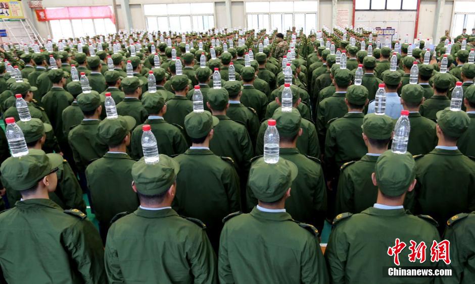 Military training with bottles balanced on heads