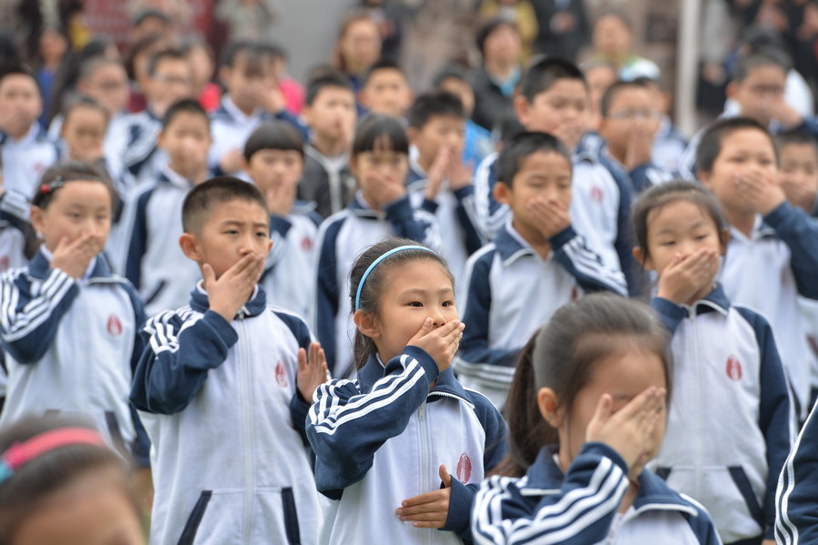 Students demonstrate new official anti-smoking gestures