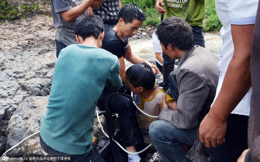 Boy plucked from cliff after falling into waterfall in SW China