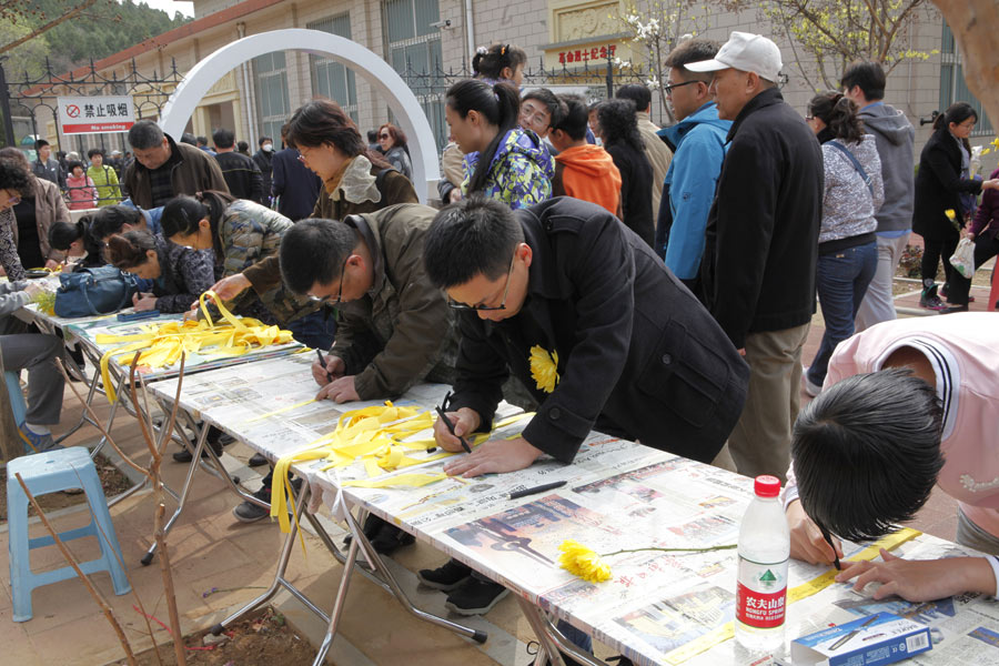 Flowers, yellow ribbons and sea burials in Tomb-Sweeping holiday