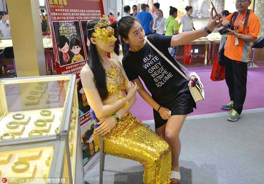 Model in golden bikini dazzles at jewelry exhibition