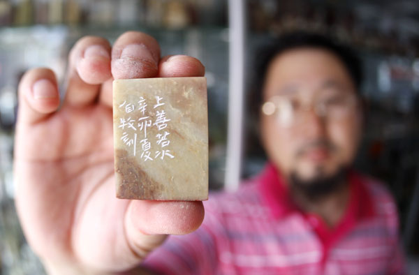 Man continues stamp carving despite struggling business