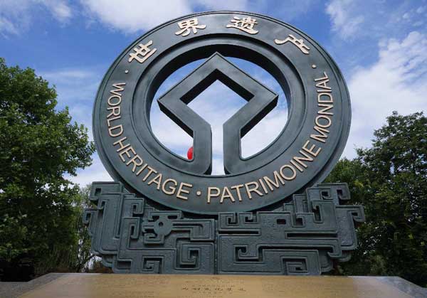 Dancers perform in front of sculpture of logo design for West Lake