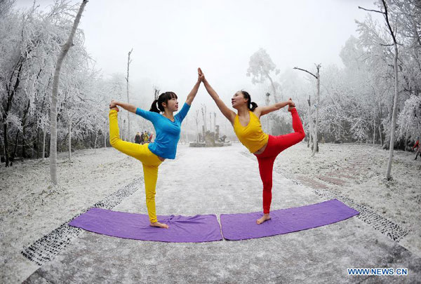 Women do yoga after snowfall