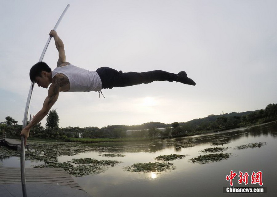 Male pole dancer shows strength and beauty