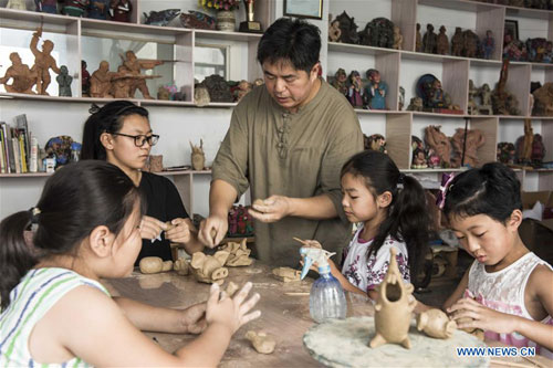 Pupils learn to make 'Qixia painted clay sculpture'