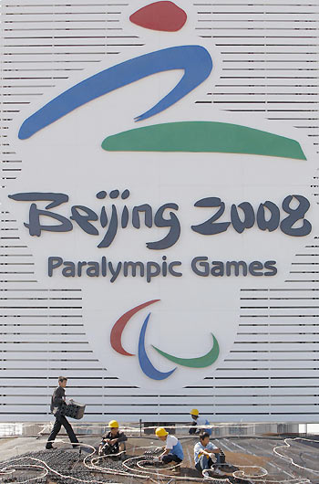 Labourers work in front of an installation with a logo of the Beijing 2008 Paralympic Games at Tiananmen Sqaure in Beijing September 1, 2008. The Paralympic Games will be held in Beijing from September 6 to 17. [Agencies]