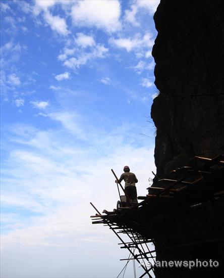 Chinese spider men work on cliffs