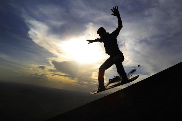 Tourists surf Cerro Negro volcano in Nicaragua