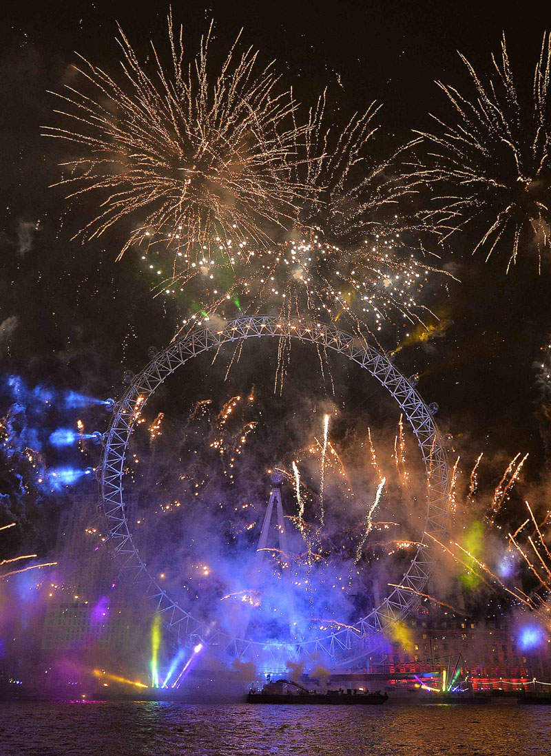 Fireworks explode around the London Eye wheel