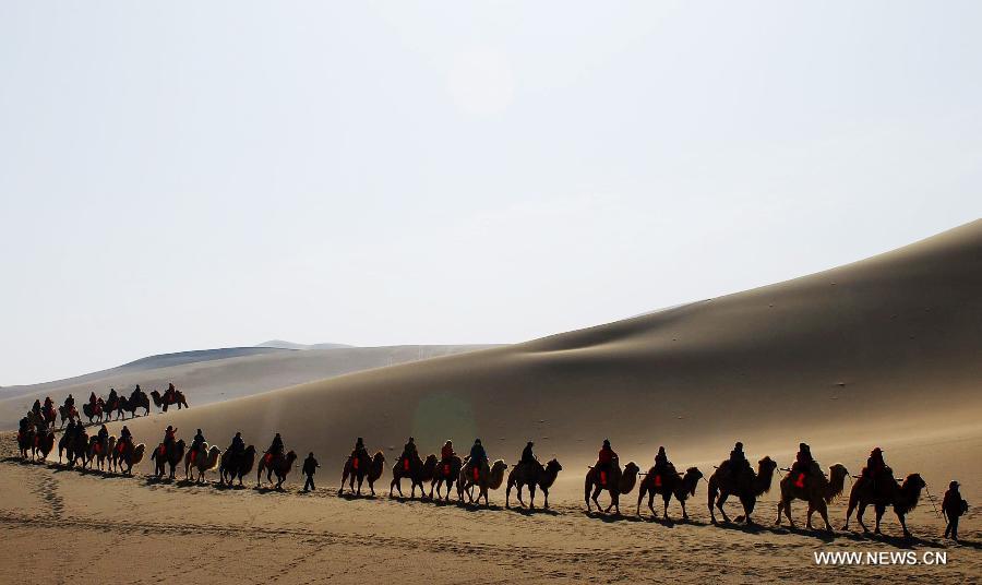 Tourists visit Crescent Moon Spring by camels