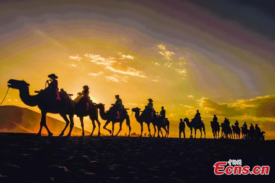 Tourists visit Mingsha Mountain in Dunhuang