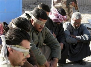 A group of suspected insurgents who were detained by joint U.S. and Iraqi forces wait inside an Iraqi military camp near Baquba, 60 km (40 miles) northeast of Baghdad, December 3, 2006. U.S.-Iraqi forces launched an offensive in the town of Baquba on Sunday, killing three insurgents and detaining 44. Three Iraqi soldiers were wounded in the operation, the U.S. military said in a statement. U.S. and Iraqi troops also captured a suspected insurgent leader during a raid on Friday near Baquba, the military said. 