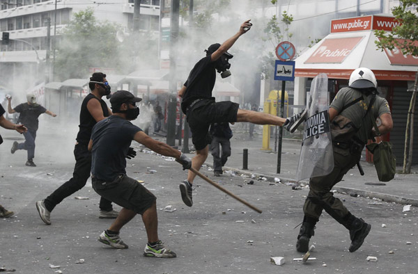 Greece passes steep cuts as riots seize capital