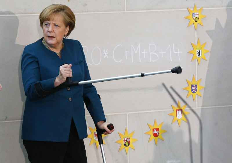 Merkel meets carols singers with crutches