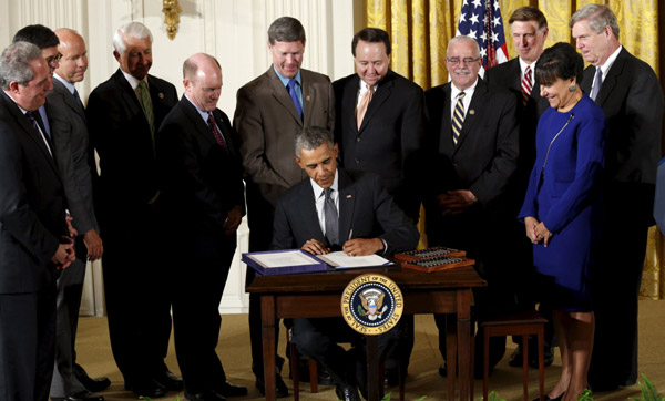 Obama signs trade bills into law, giving boost to TPP talks